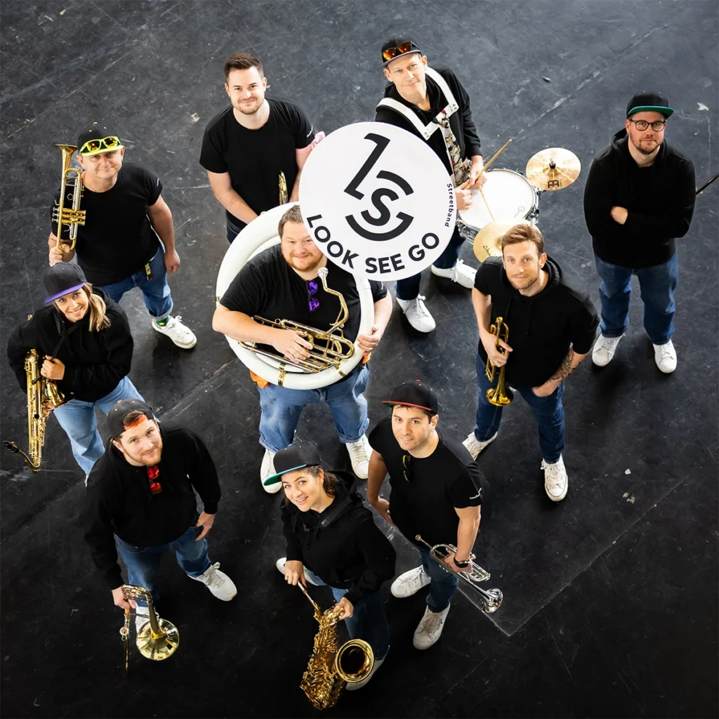 Look See Go, fanfare de rue valaisanne, pour une performance festive à la Braderie d’Aigle avec trompettes, trombones et saxophone.